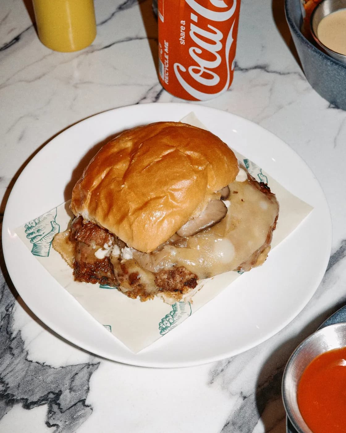 Burger on a plate with a Coke can