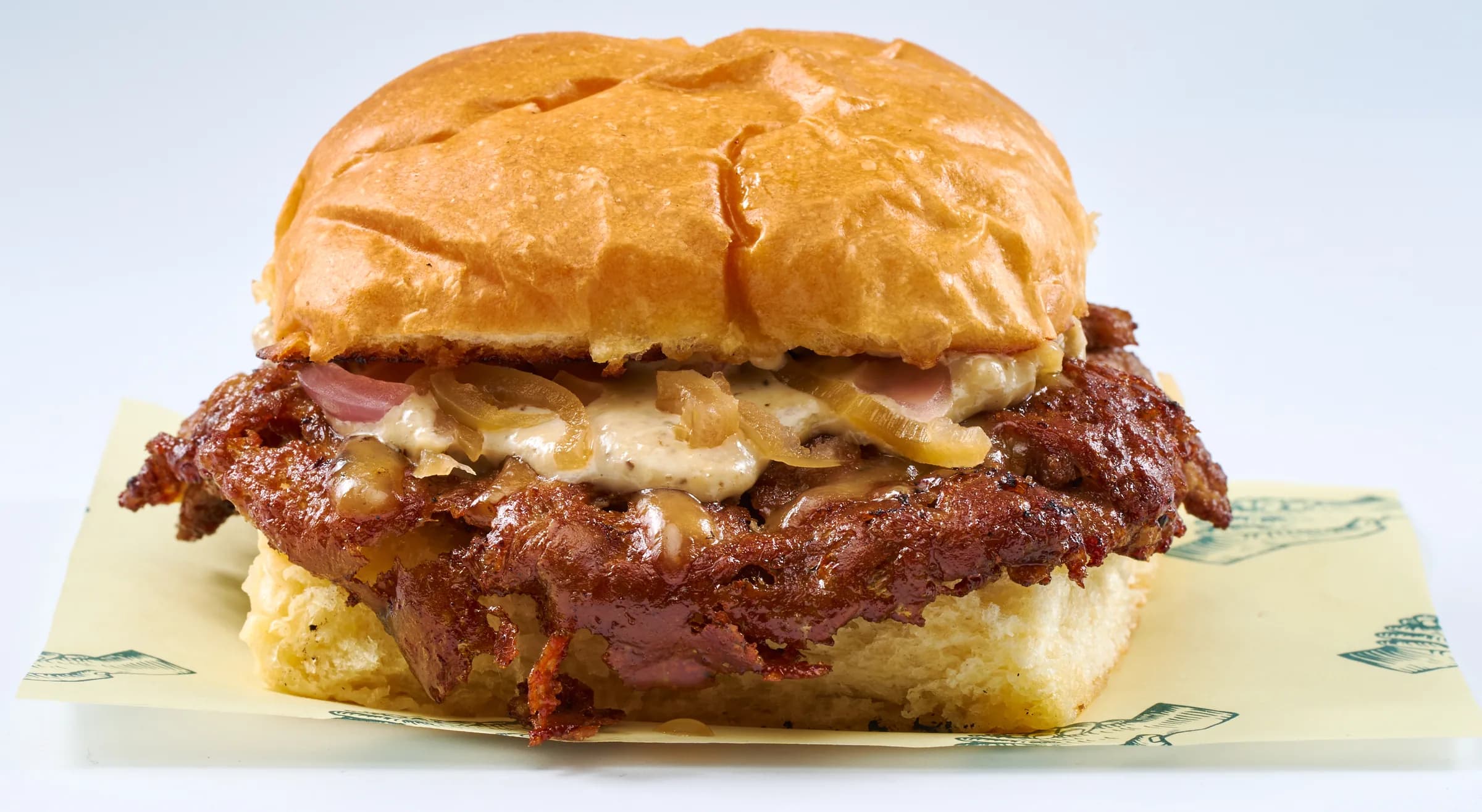 Umami Truffle Burger with gouda and chili onion relish on a potato bun